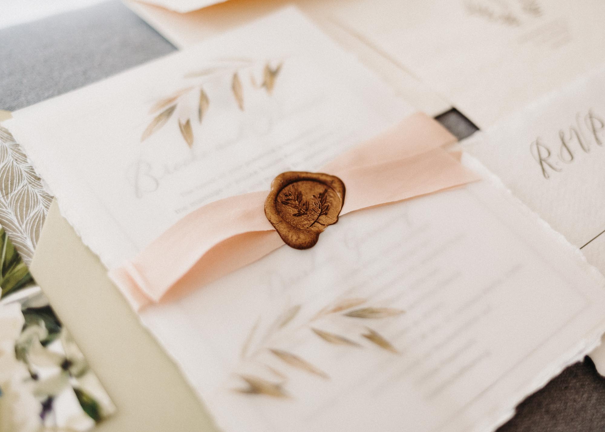 Detailaufnahme von Hochzeitspapeterie mit Seidenband und Wachssiegel