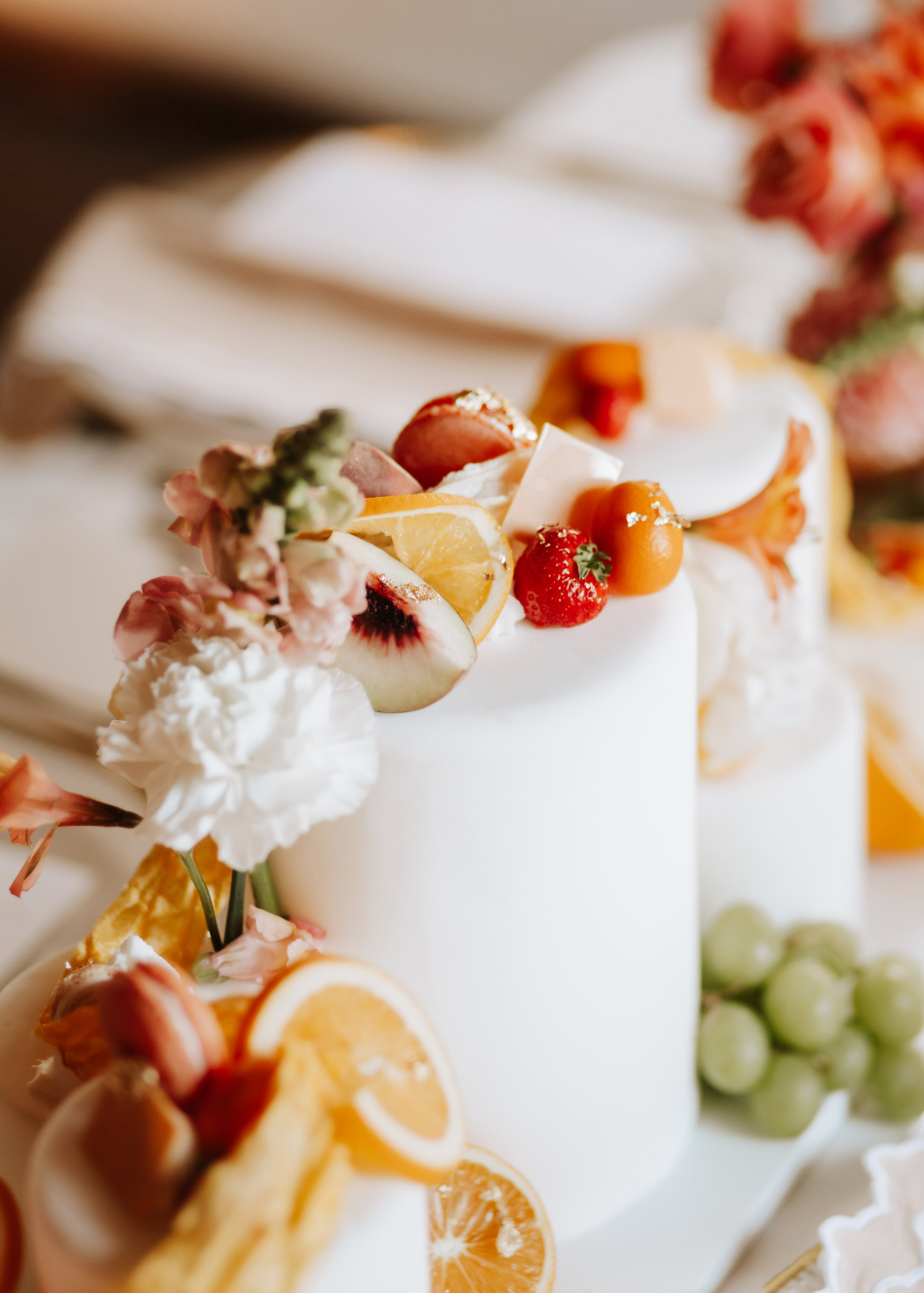 Moderne sommerliche Hochzeitstorte mit Früchten und Blumen