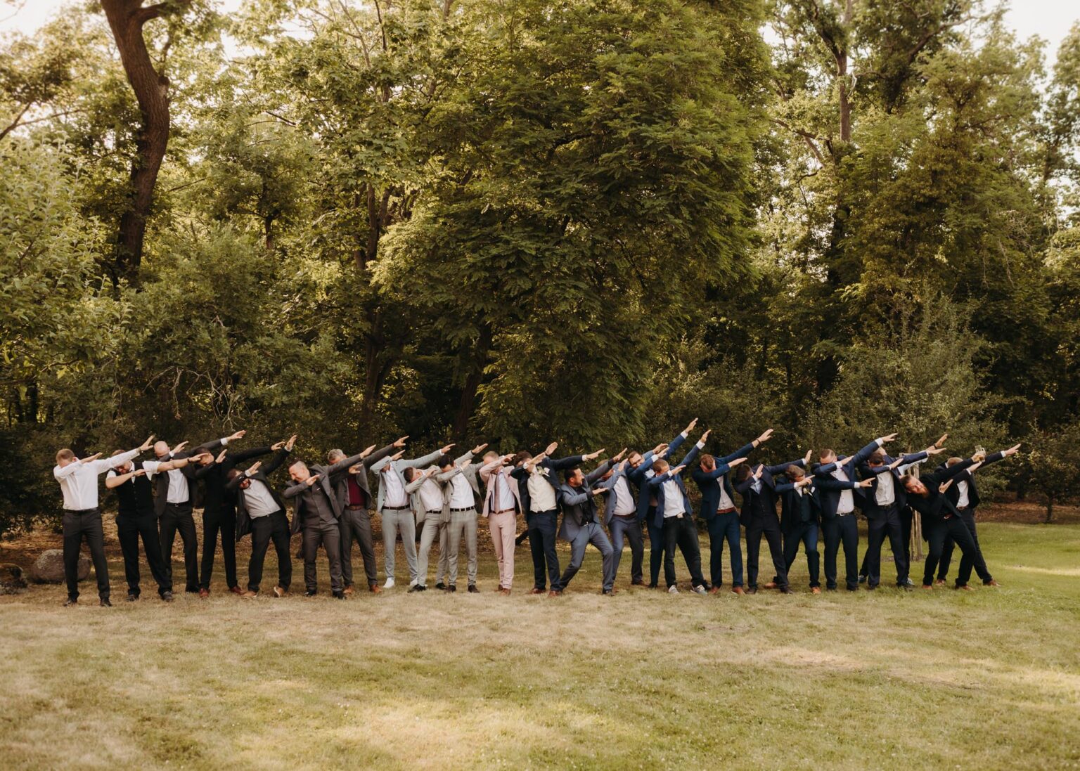 Lustiges Gruppenbild mit Bräutigam und Gästen im Park in Oranienbaum – Hochzeitsfotograf Oranienbaum-Wörlitz