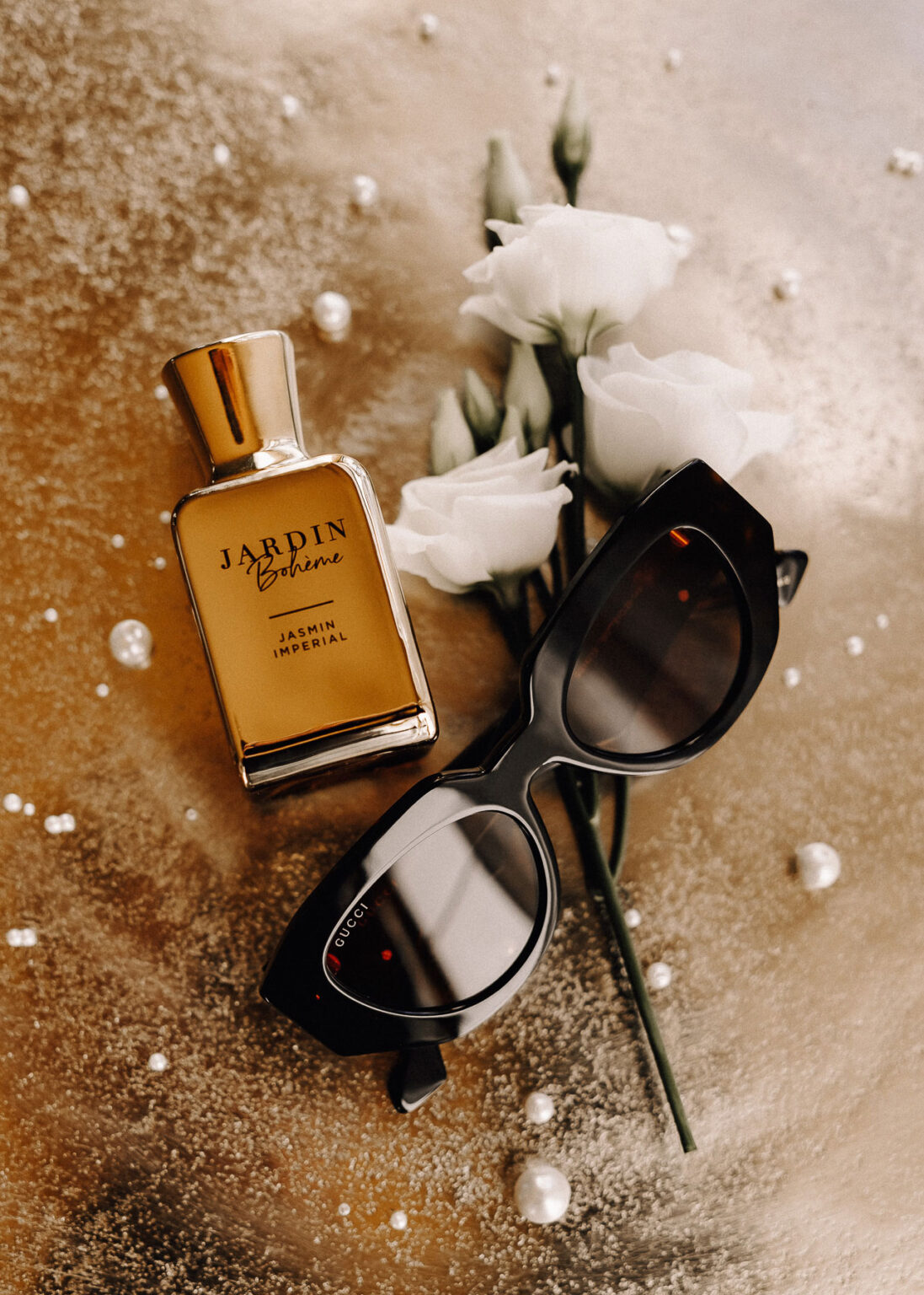 Arrangement moderner Accessoires für die Braut mit Sonnenbrille und Parfum